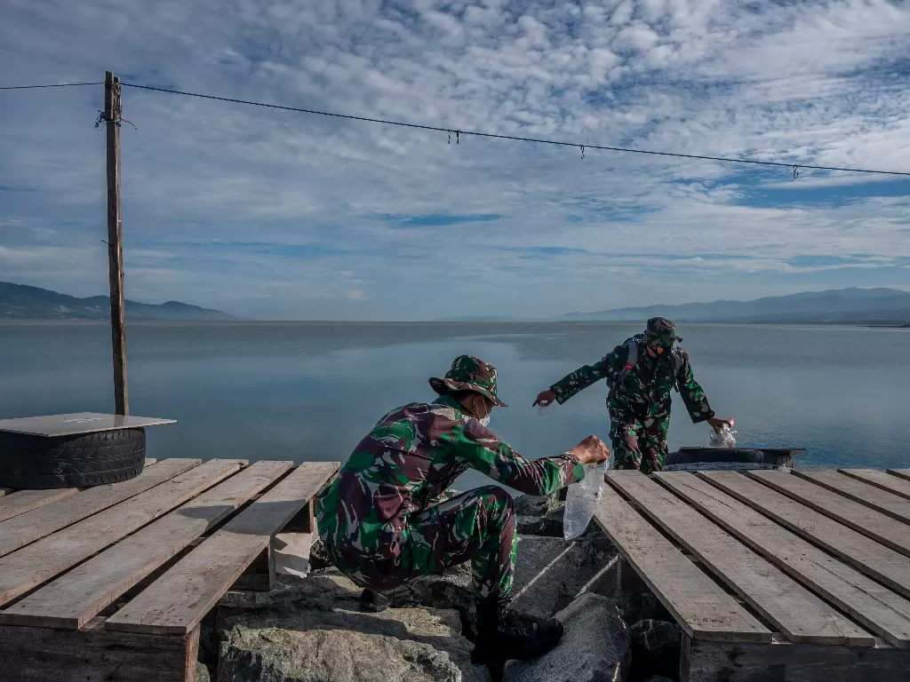 Dua prajurit TNI AD memungut sampah plastik yang berserakan (ANTARAFOTO/Basri Marzuki)