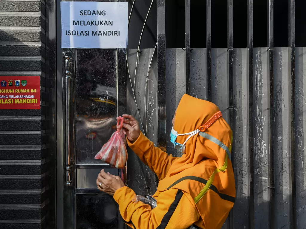 Anggota satuan tugas penanganan COVID-19 menggantungkan makanan di pagar rumah warga yang menjalani isolasi mandiri di kawasan Warakas, Tanjung Priok, Jakarta Utara, Selasa (22/6/2021). (ANTARA/M Risyal Hidayat)