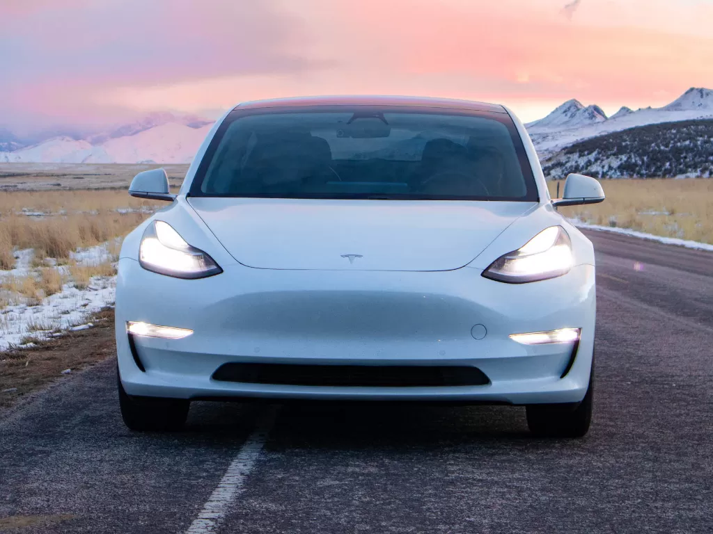 Tampilan depan dari mobil listrik besutan Tesla berwarna putih (photo/Unsplash/Taun Stewart)
