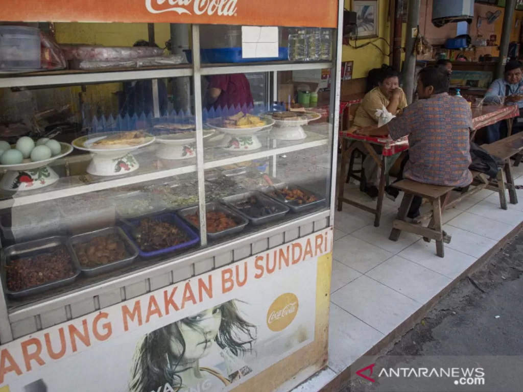 Sejumlah warga menyantap sajian yang dijual salah satu warung makan di Kemayoran, Jakarta, Senin (26/7/2021). (photo/ANTARA FOTO/Aditya Pradana Putra/ilustrasi)