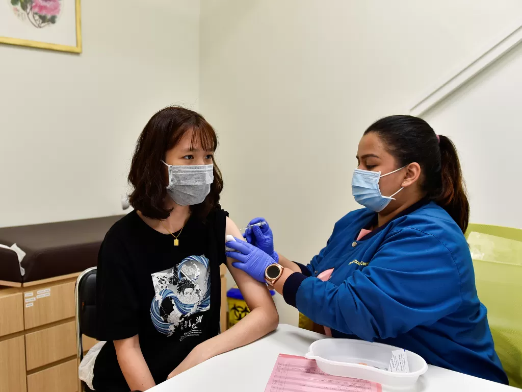 Perawat di StarMed Specialist Centre, memberikan vaksin Sinovac kepada Yan Shu Hung, 21, di Singapura 13 Juli 2021. (photo/REUTERS/Caroline Chia/ilustrasi)