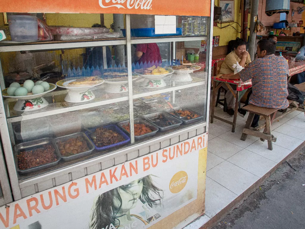 Sejumlah warga menyantap sajian yang dijual salah satu warung makan di Kemayoran, Jakarta (ANTARA FOTO/Aditya Pradana Putra)