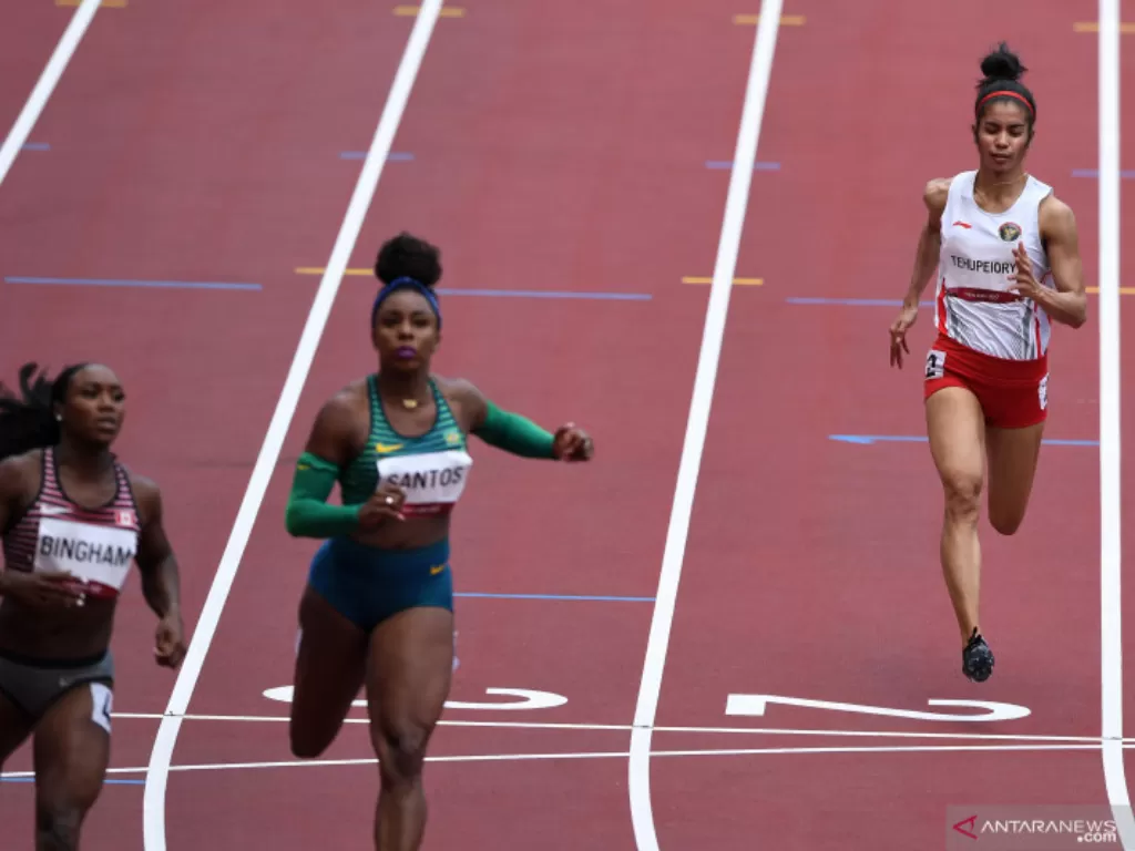 Sprinter Indonesia Alvin Tehupeiory (kanan) melintasi garis finish dalam babak pertama 100 meter putri cabang atletik Olimpiade Tokyo (ANTARA FOTO/SIGID KURNIAWAN)