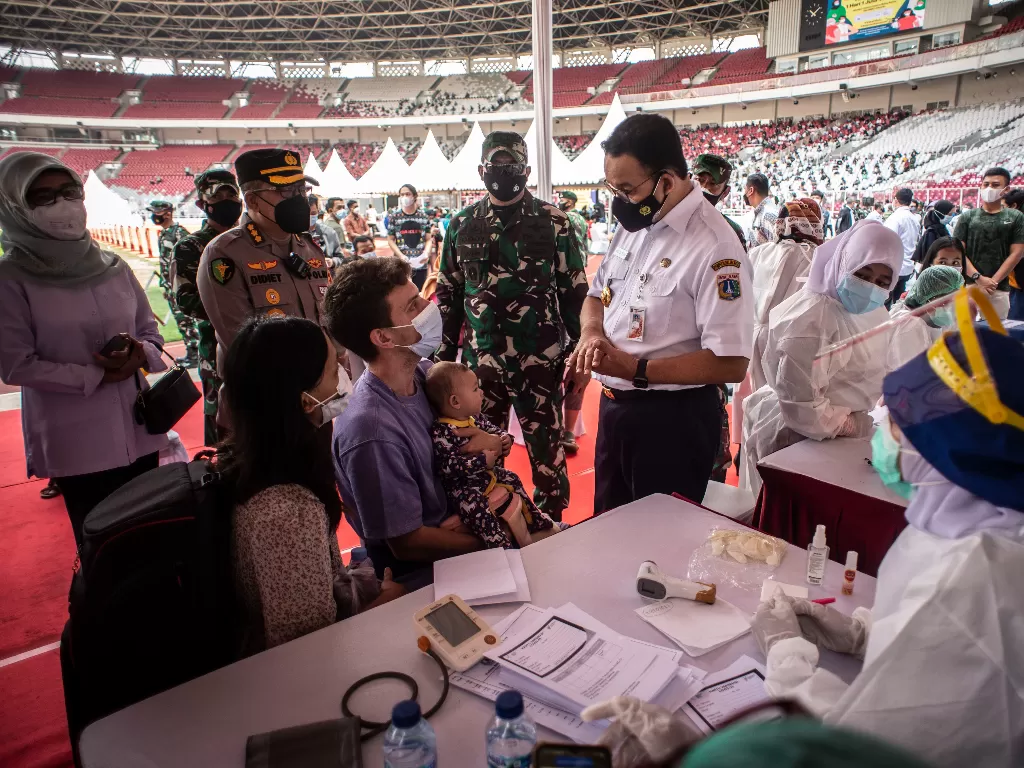 Gubernur DKI Jakarta Anies Baswedan (kanan) berbincang dengan warga calon penerima vaksin COVID-19 (ANTARA FOTO/Aprillio Akbar/hp.)