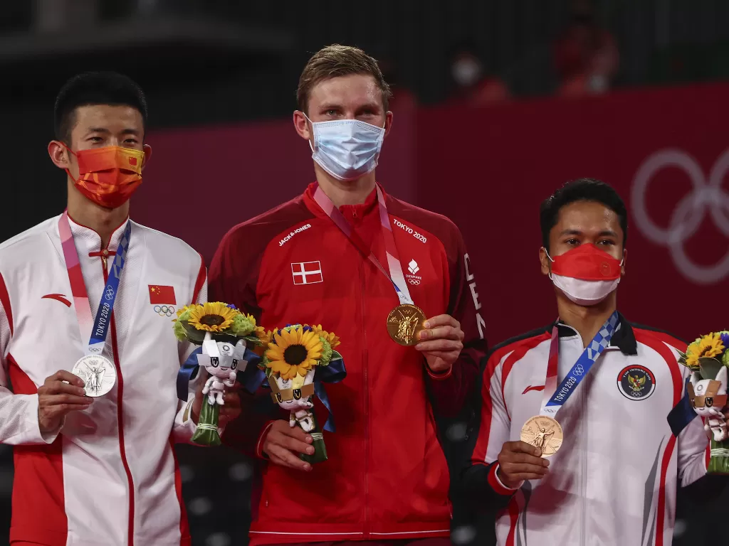 Peraih medali emas Viktor Axelsen dari Denmark, peraih medali perak Chen Long dari China, dan peraih medali perunggu Anthony Ginting dari Indonesia berpose bersama, Selasa (2/8) (photo/REUTERS/Leonhard Foeger)