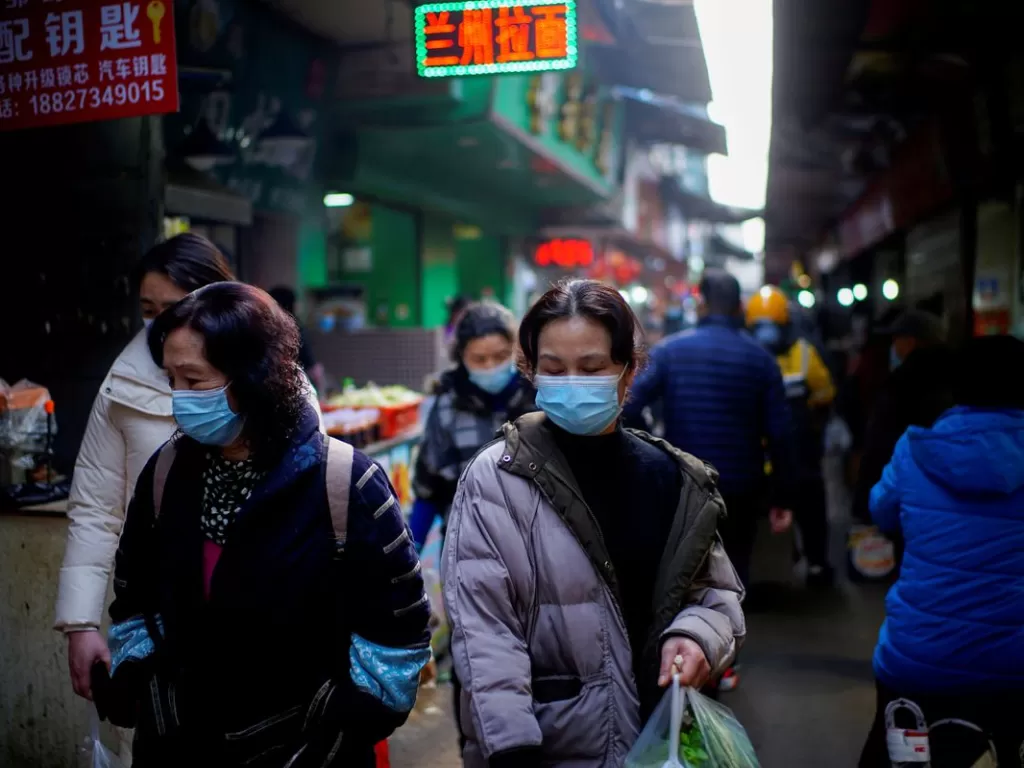 Orang-orang memakai masker di Wuhan, Provinsi Hubei, 8 Februari 2021. (REUTERS/Aly Song)