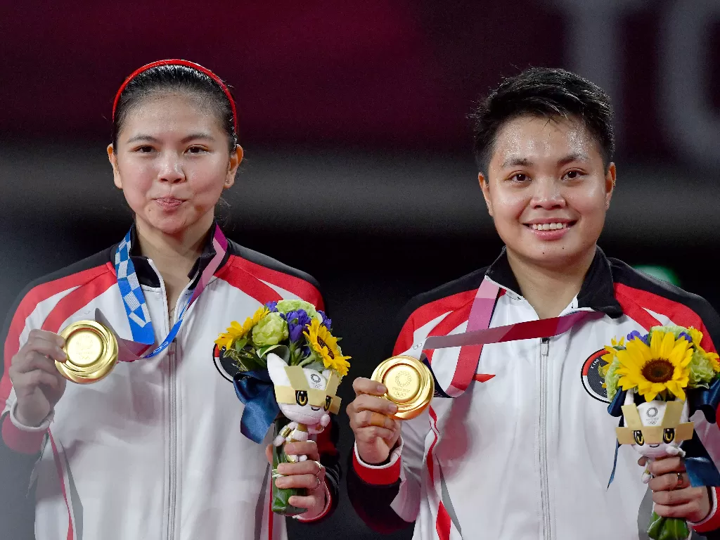 Pebulutangkis ganda Putri Indonesia Greysia Polii (kiri) dan Apriyani Rahayu memperlihatkan medali emas yang berhasil mereka raih  (ANTARA /Sigid Kurniawan)