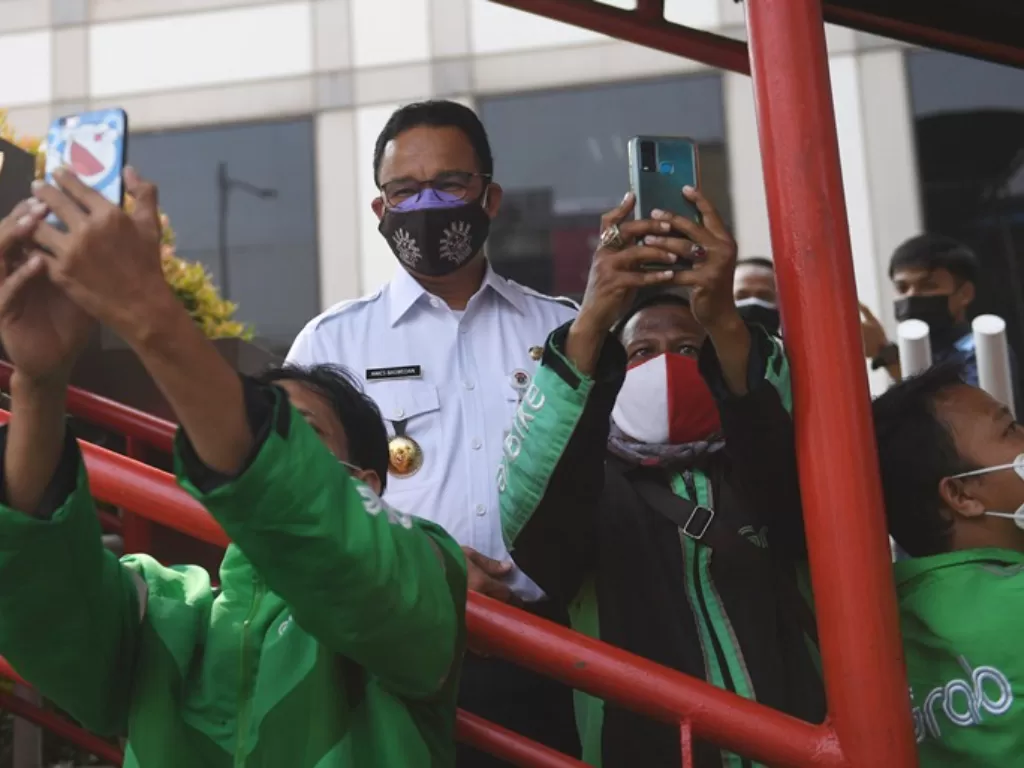 Gubernur DKI Jakarta Anies Baswedan melayani permintaan swafoto pengemudi ojek daring (ANTARA FOTO/Akbar Nugroho Gumay)
