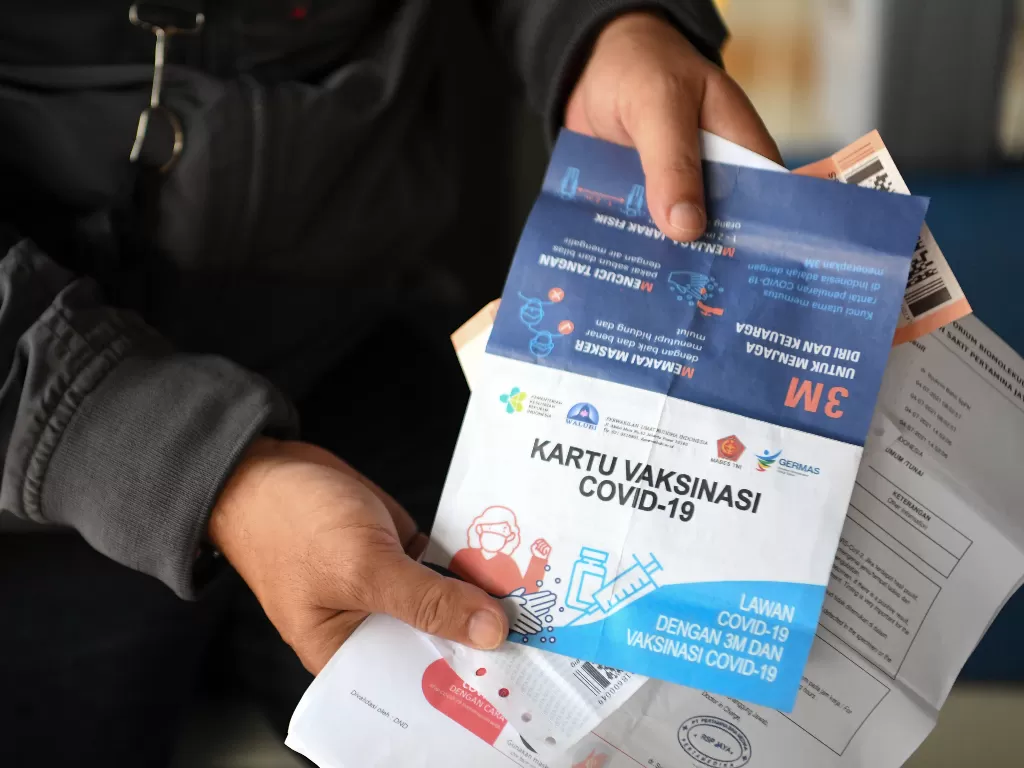 Calon penumpang Kereta Api Jayabaya tujuan Malang menunjukan kartu vaksinasi di Stasiun Pasar Senen, Jakarta (ANTARA FOTO/Hafidz Mubarak A/pras.)