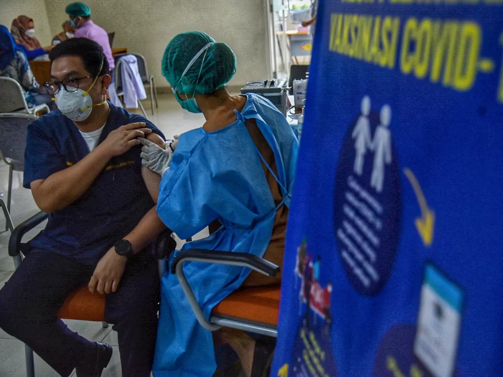 Petugas menyuntikkan vaksin Moderna kepada tenaga kesehatan yang menjalani vaksinasi COVID-19 dosis ketiga di Rumah Sakit Umum Pusat (RSUP) Haji Adam Malik, Medan, Sumatera Utara, Kamis (5/8/2021). (ANTARA/Fransisco Carolio)