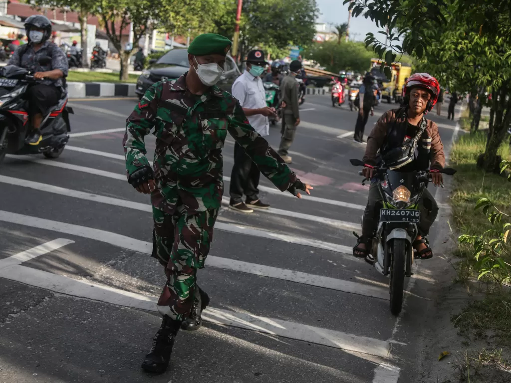 Petugas TNI menghentikan pengendara yang melanggar protokol kesehatan (ANTARA FOTO/Makna Zaezar)