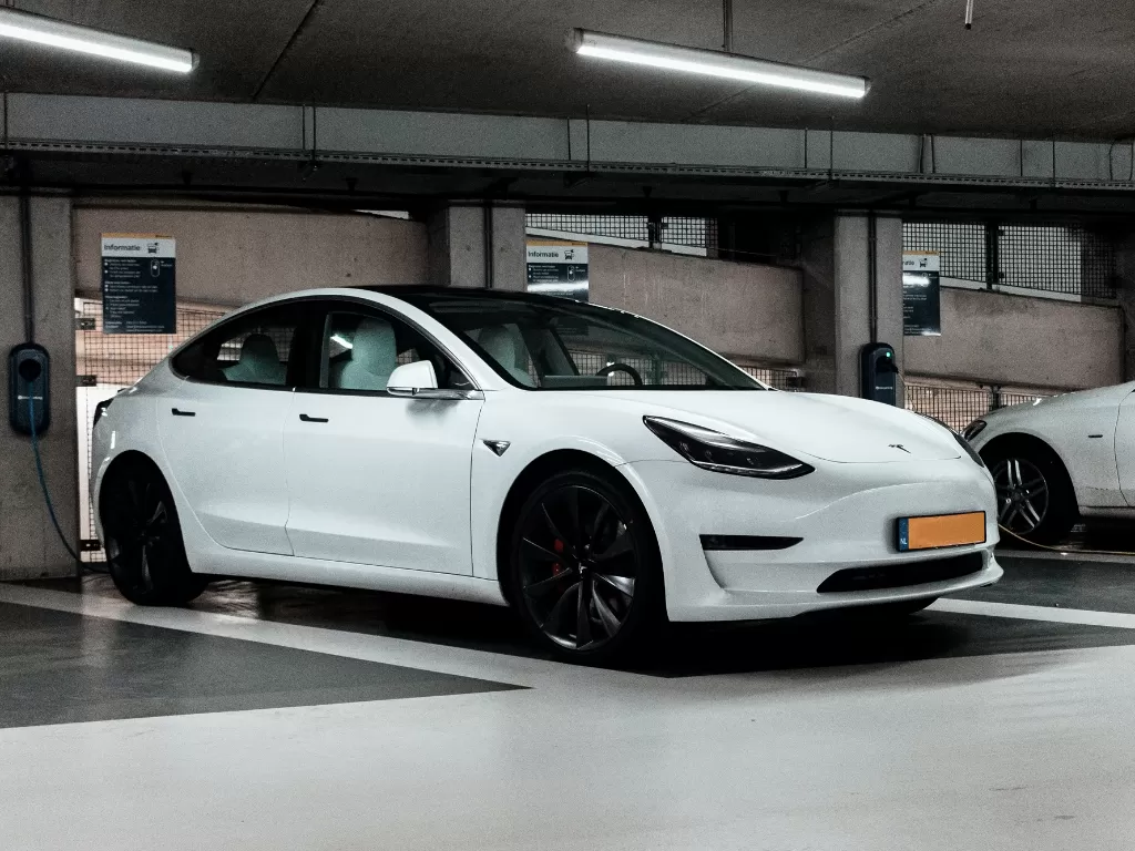 Tampilan mobil listrik besutan Tesla berwarna putih (photo/Unsplash/Jannis Lucas)