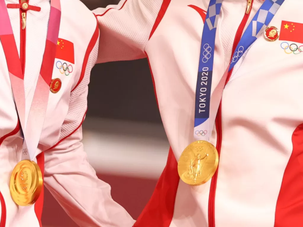 Atlet balap sepeda Bao Shanju dan Zhong Tianshi dari China mengenakan pin bergambar mendiang pemimpin China Mao Zedong saat pengalungan medali emas di Olimpiade Tokyo, Izu Velodrome, Shizuoka, Jepang. (2/8/2021) (photo//REUTERS/Matthew Childs)