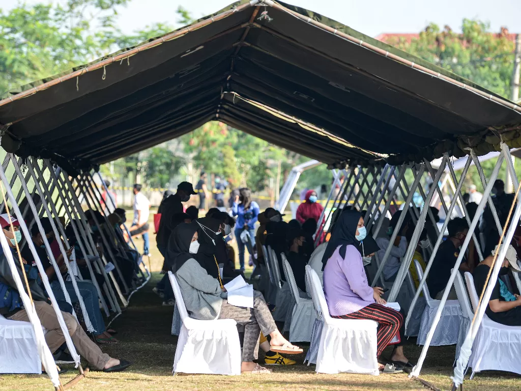 Sejumlah warga sekitar duduk di bawah tenda saat akan melakukan vaksinasi COVID-19 (ANTARA FOTO/M Risyal Hidayat/aww.)
