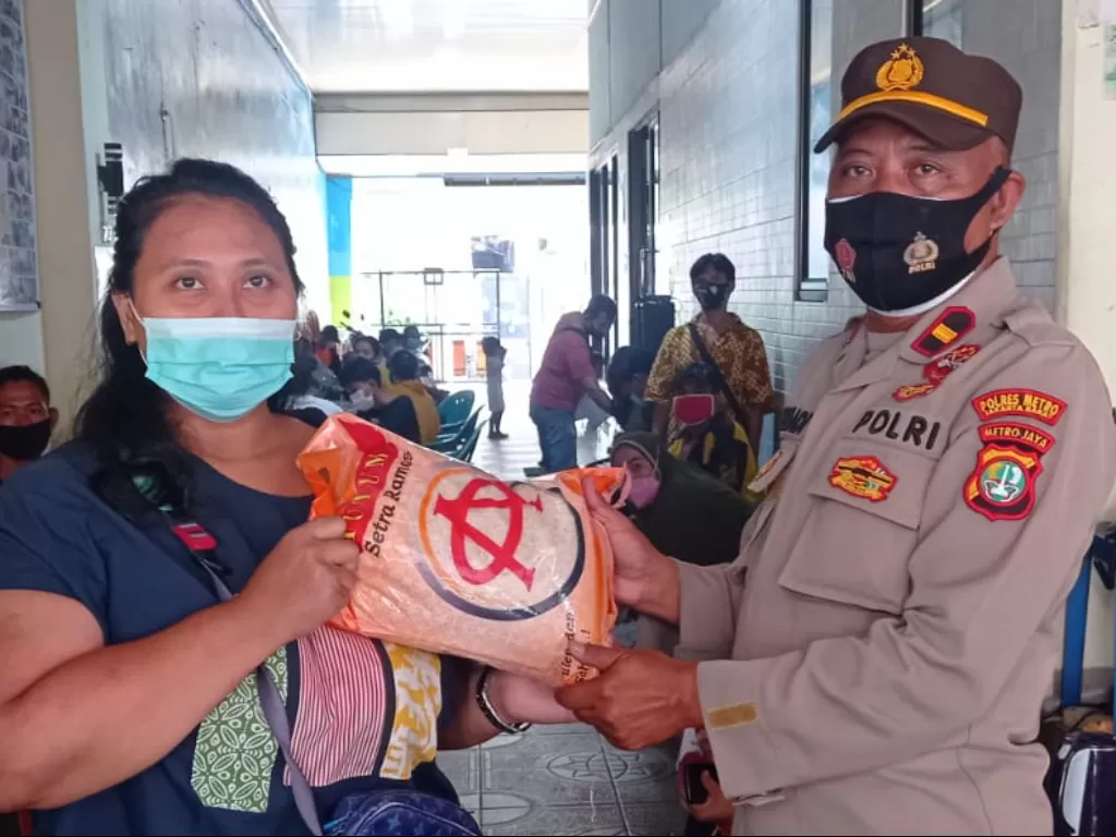 Seorang warga yang sudah divaksin diberikan hadiah oleh pihak Polsek Tanjung Duren agar warga lain juga tertarik ikut sukseskan program vaksinasi. (Dok. Polsek Tanjung Duren)