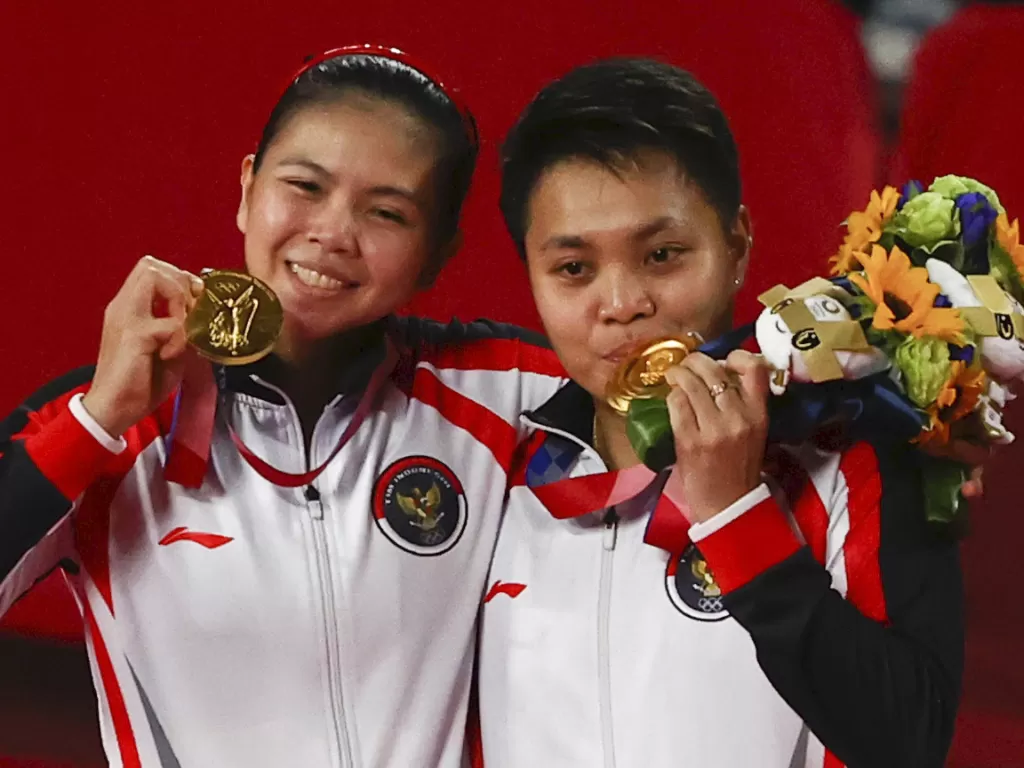 Peraih medali emas Greysia Polii dari Indonesia dan Apriyani Rahayu dari Indonesia berpose dengan medali mereka. (photo/REUTERS/Hamad I Muhammad/ilustrasi)