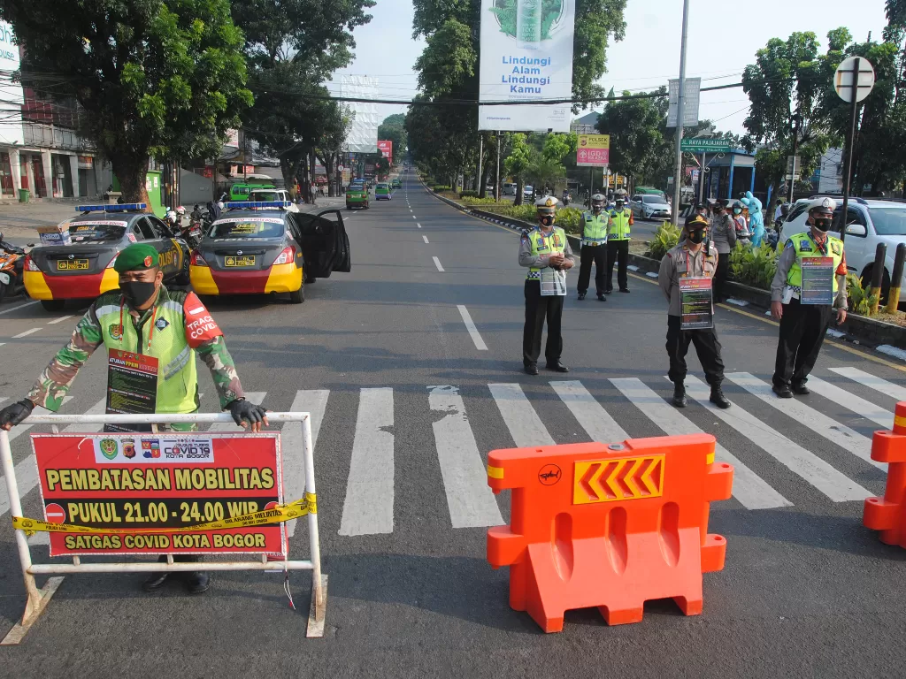 Sejumlah personel Polresta Bogor Kota bersama TNI AD menutup jalan Simpang Warung Jambu, Kota Bogor, Jawa Barat, Sabtu (17/7/2021). (photo/ANTARA FOTO/Arif Firmansyah/ilustrasi)