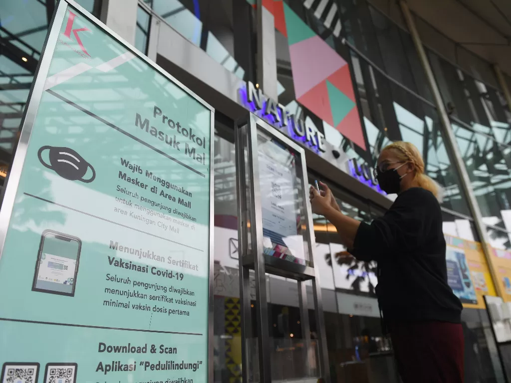 Pengunjung memindai barcode melalui aplikasi PeduliLindungi sebelum memasuki Mall (ANTARA/Akbar Nugroho Gumay)