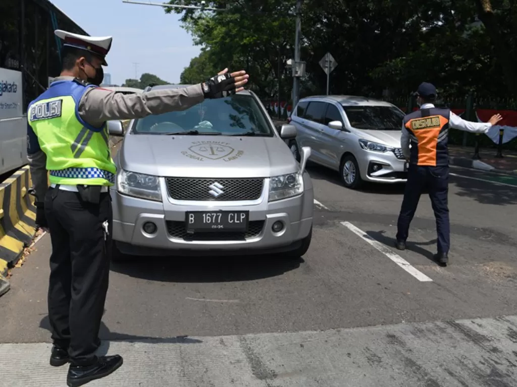 Petugas kepolisian melarang pengendara mobil berplat nomor ganjil memasuki Jalan Sudirman (ANTARA FOTO/Hafidz Mubarak)