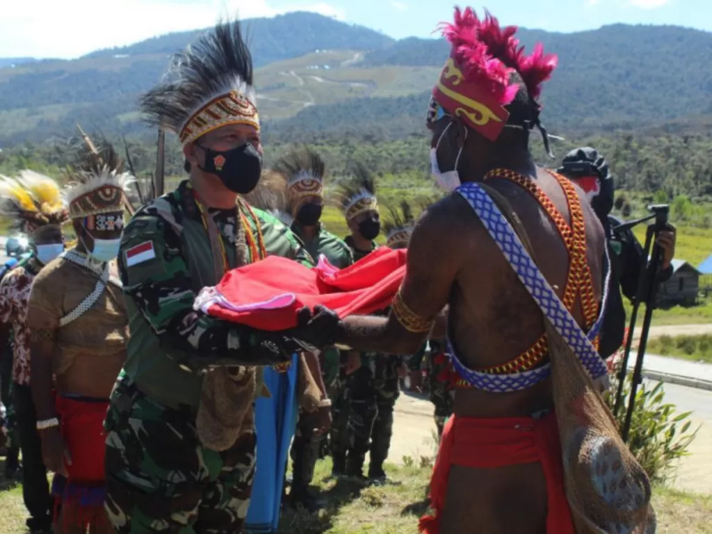 Pangdam XVIII/Kasuari Mayjen TNI I Nyoman Cantiasa menyerahkan bendera merah putih kepada kepala-kepala suku Kabupaten pegunungan Arfak, Provinsi Papua Barat. (ANTARA/HO-Kodam XVIII/Kasuari) 