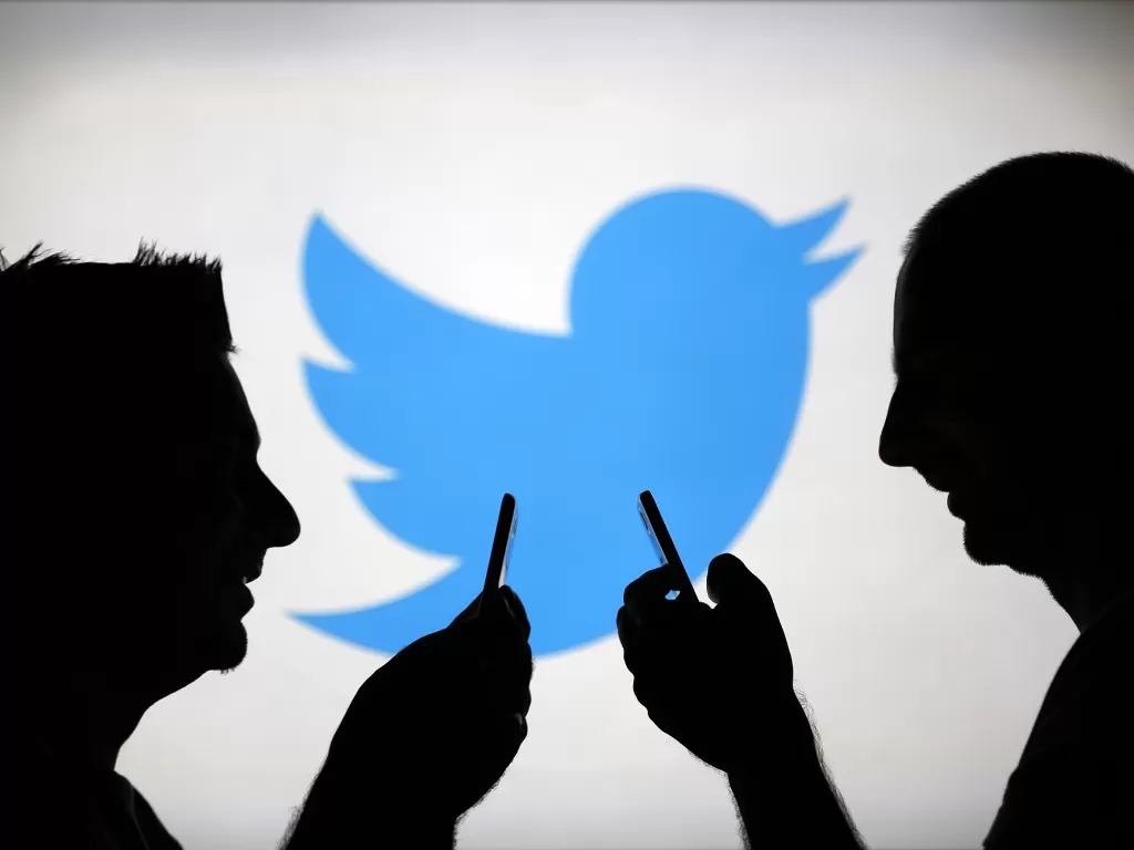 Ilustrasi dua orang pria dengan logo Twitter di belakang (photo/REUTERS/Dado Ruvic)