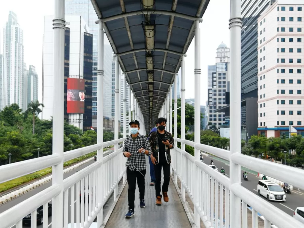 Warga menggunakan masker di jembatan penyeberangan Jakarta, 17 Juni 2021. (REUTERS/Ajeng Dinar Ulfiana)