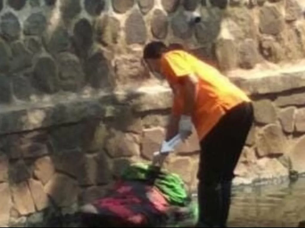 Petugas memeriksa jenazah yang ditemukan di aliran Sungai Cibogo, Kelurahan Mekarjaya, Kecamatan Rancasari, Kota Bandung, Senin (16/8/2021). (Instagram/@bandungtalk)