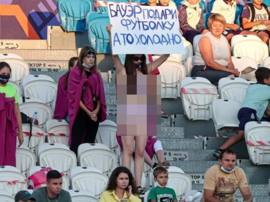 Wanita fans klub Rusia buka baju di tribun sambil bawa spanduk untuk minta jersey pemain. (photo/Daily Star)
