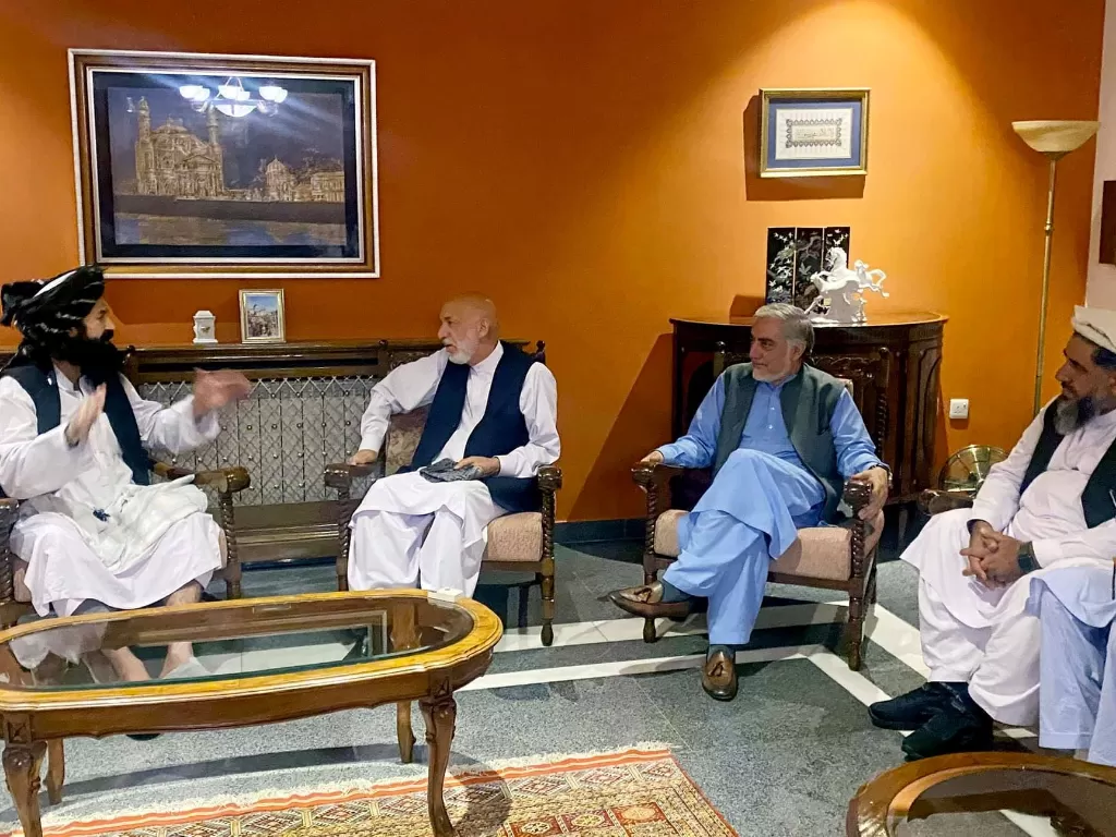 Mantan Presiden Afghanistan Hamid Karzai, didampingi oleh utusan perdamaian utama pemerintah lama, Abdullah Abdullah, duduk untuk berbicara dengan anggota delegasi Taliban, 19 Agustus 2021.  (photo/Handout via REUTERS)