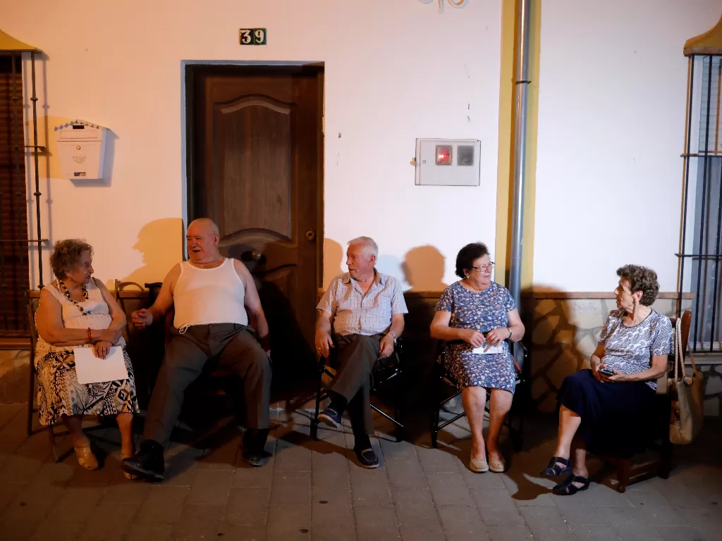 Tampilan warga Algar yang duduk dan nongkrong bersama tetangga saat musim panas. (photo/REUTERS/JON NAZCA)