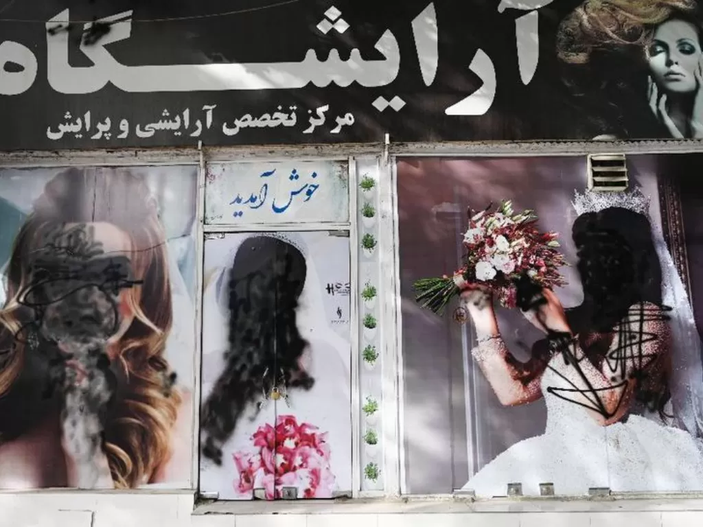 Poster salon kecantikan yang  dicoret-coret kawanan Taliban. (photo/Dok. Wakil KOHSAR/AFP)
