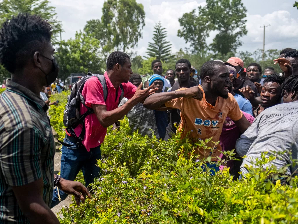 Warga Haiti berebut amplop berisi bantuan uang tunai (REUTERS/Ricardo Arduengo)