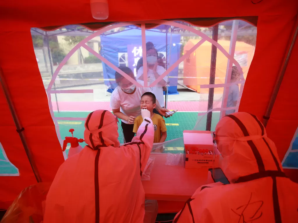 Seorang anak kecil sedang melakukan tes kesehatan di  Yangzhou, China. (Reuters)