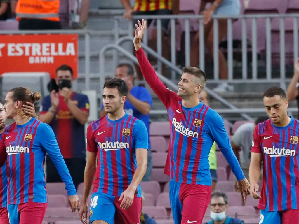 Gerard Pique melambaikan tangan ke fans dan merayakan golnya untuk Barcelona (REUTERS/Albert Gea)