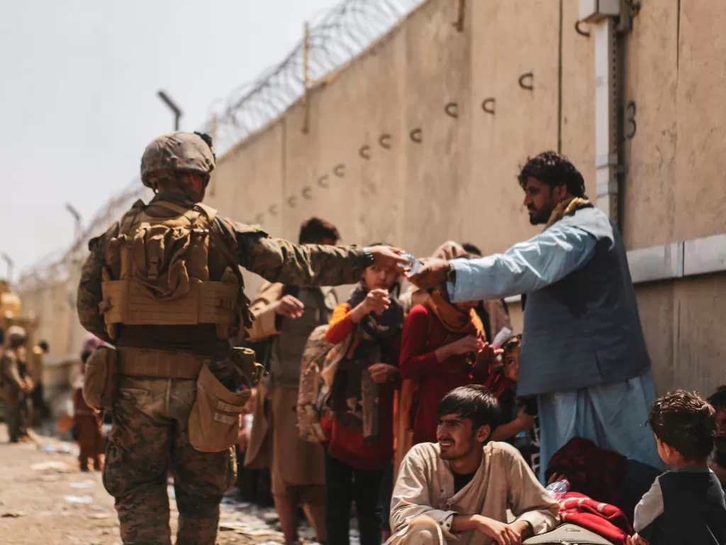 Marinir Amerika Serikat memberikan air pada penduduk Afghanistan di Bandara Hamid Karzai (Reuters)