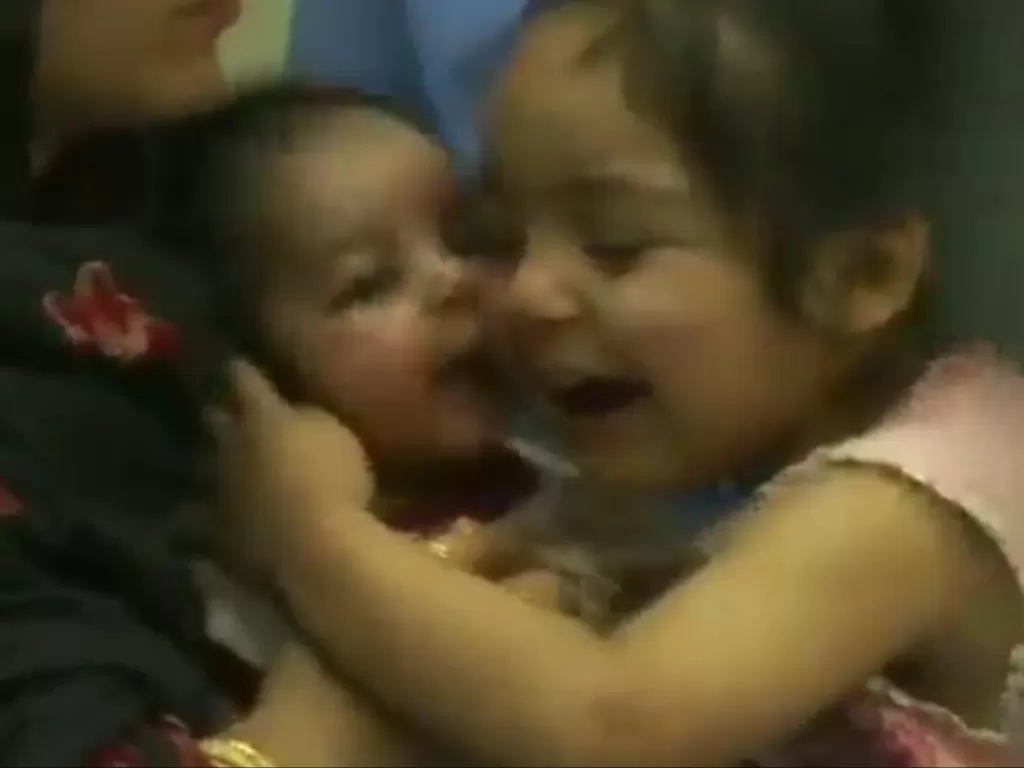 Momen gadis kecil mencium bayi setelah berhasil keluar dari Afghanistan. (Photo/Twitter/ANI)