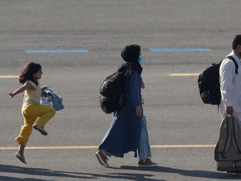 Potret gadis Afghanistan melompat di bandara Belgia. (REUTERS/Johanna Geron)