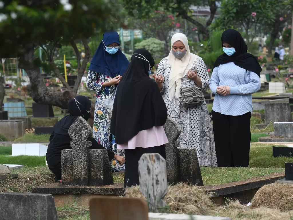 Warga berdoa saat melakukan ziarah kubur di TPU Karet Bivak, Jakarta. (ANTARA/Akbar Nugroho Gumay)