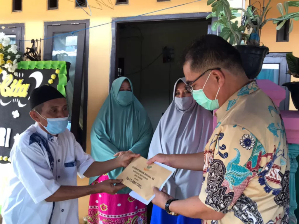 Direktur Perlindungan Sosial Korban Bencana Sosial (PSKBS) Harapan Lumban Gaol memberikan Santunan Ahli Waris kepada keluarga Novandri, korban meninggal insiden Mal Margocity di rumah duka di Jakarta, Sabtu (28/8/2021). (ANTARA/HO-Kemensos)