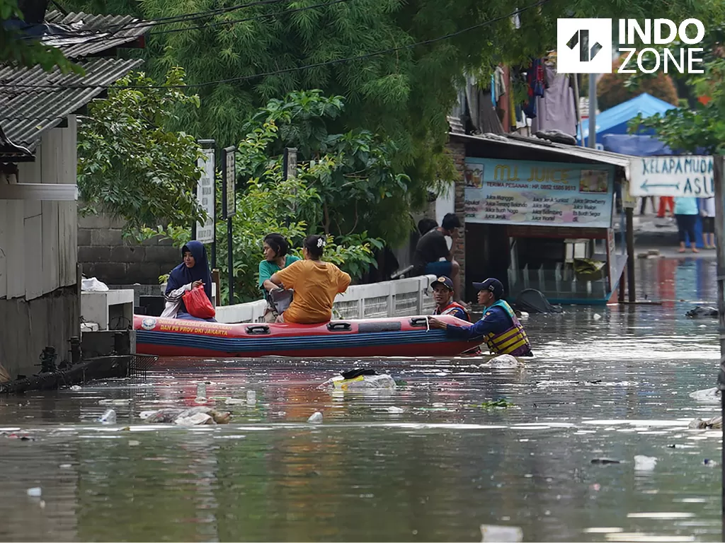 Warga melintasi banjir di kawasan Karet Tengsin, Tanah Abang, Jakarta Pusat, Selasa (25/2/2020). (INDOZONE)