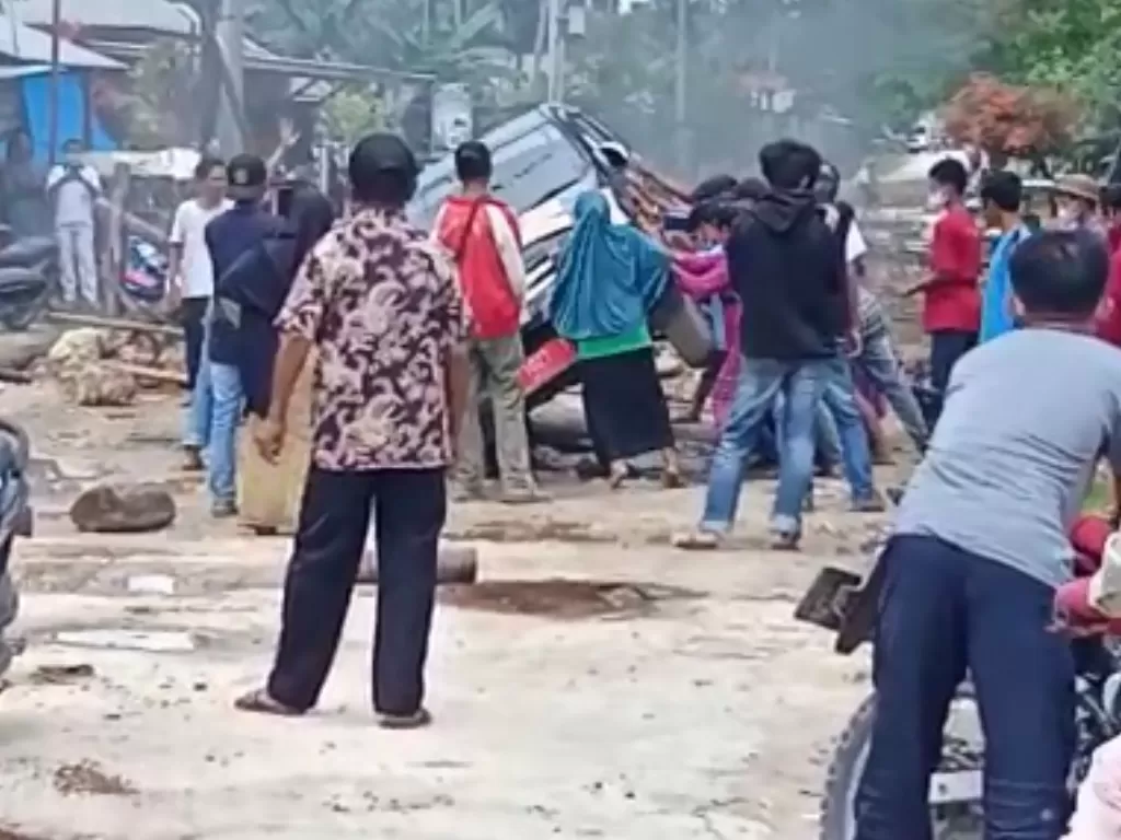 Warga ramai-ramai menggulingkan mobil dinas saat melintasi Desa Wakumoro, Kabupaten Muna, Sulawesi Tenggara.(Istimewa)