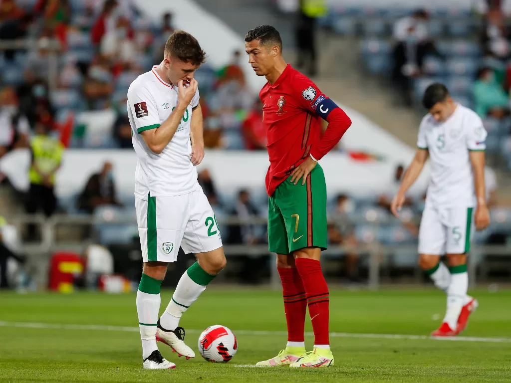 Cristiano Ronaldo memukul pemain Irlandia. (photo/REUTERS/Pedro Nunes)