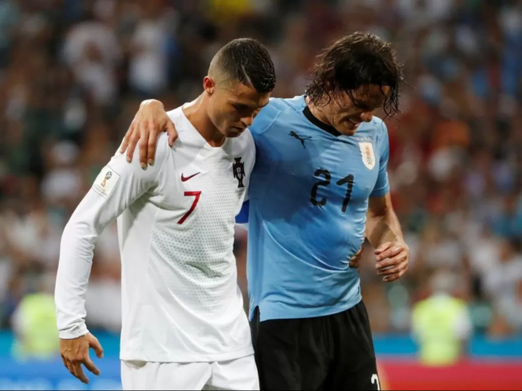 Cristiano Ronaldo membantu Edinson Cavani. (REUTERS/Jorge Silva)