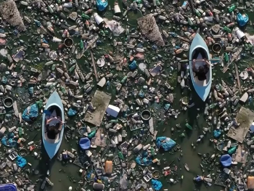 Seseorang mendayung di atas permukaan laut dipenuhi sampah plastik (Instagram/joshwideawake)