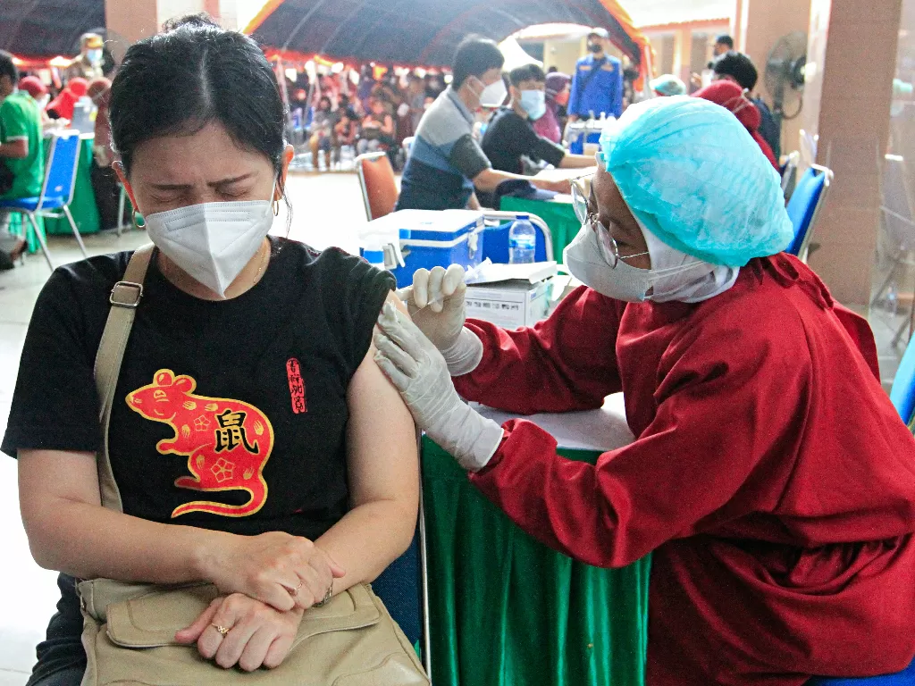 Seorang wanita saat menerima dosis vaksin penyakit coronavirus (COVID-19) selama program vaksinasi massal di Pusat Pemerintahan Kota Tangerang, di Tangerang di pinggiran Jakarta, Indonesia, 30 Juni 2021. (photo/REUTERS/Ajeng Dinar Ulfiana/ilustrasi)