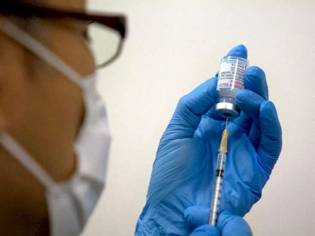Ilustrasi seseorang akan menerima suntikan vaksin. (foto/Ilustrasi/Carl Court/Pool via REUTERS)