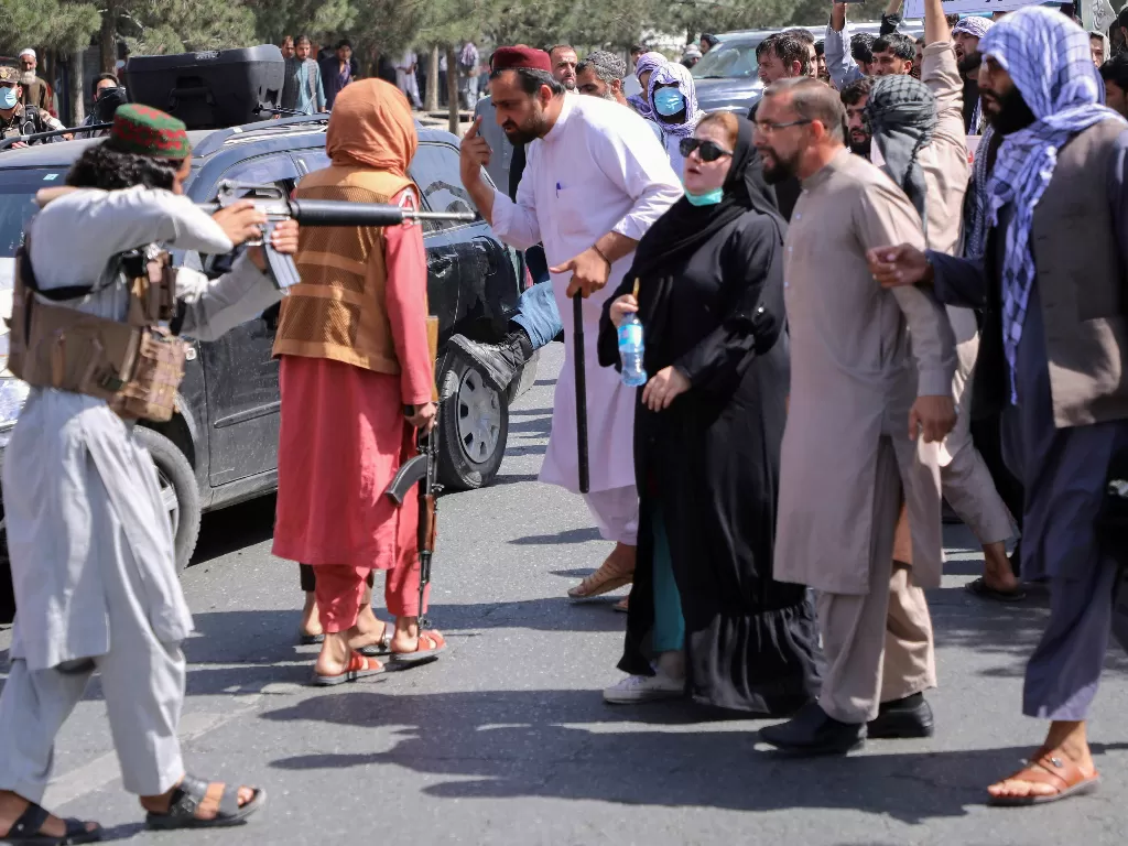 Wanita Afghanistan tetap berdiri meski Taliban menodongkan senjatanya. (REUTERS/Stringer)
