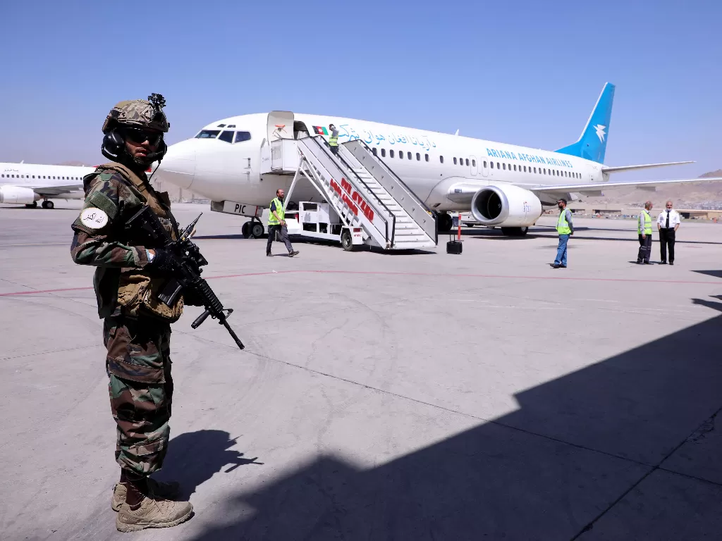  Seorang anggota pasukan Taliban berjaga di samping pesawat yang tiba dari Kandahar di Bandara Internasional Hamid Karzai di Kabul, Afghanistan, 5 September 2021. (photo/REUTERS/Stringer/ilustasi).