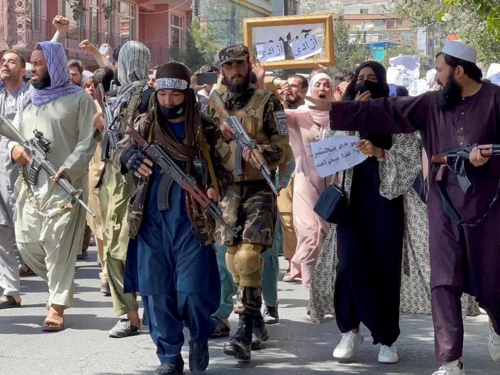 Pasukan Taliban berjalan di depan demonstran Afghanistan saat mereka meneriakkan slogan-slogan selama protes anti-Pakistan. ( REUTERS/Stringer)