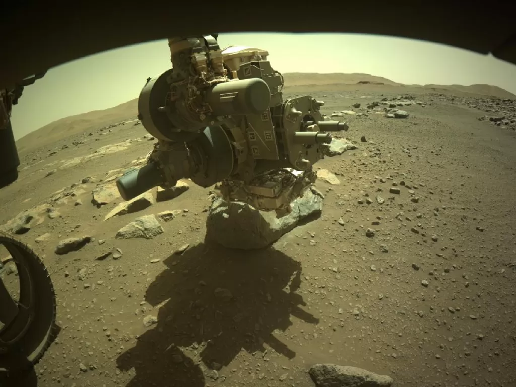 Lengan robot dari rover Perseverance yang sedang mengambil sampel batuan Mars (photo/Twitter/@NASAPersevere)